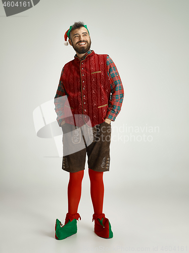 Image of friendly man dressed like a funny gnome posing on an isolated gray background