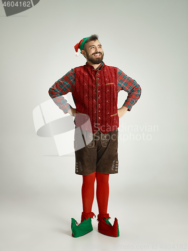 Image of friendly man dressed like a funny gnome posing on an isolated gray background