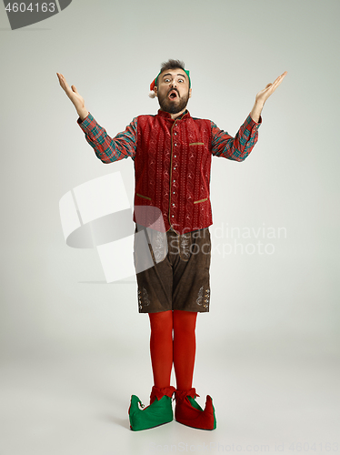 Image of friendly man dressed like a funny gnome posing on an isolated gray background