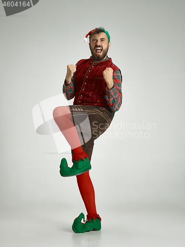 Image of friendly man dressed like a funny gnome posing on an isolated gray background