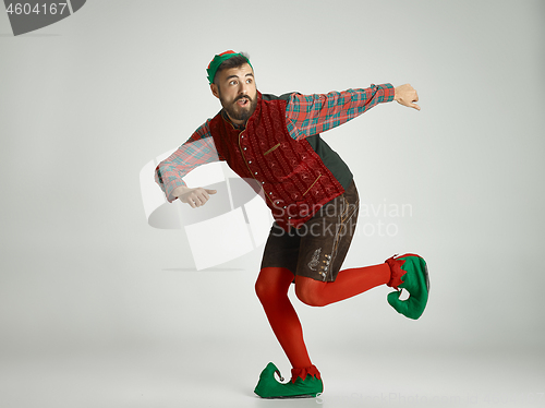 Image of friendly man dressed like a funny gnome posing on an isolated gray background