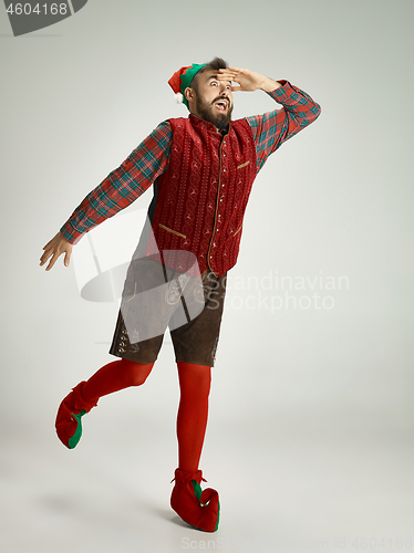 Image of friendly man dressed like a funny gnome posing on an isolated gray background