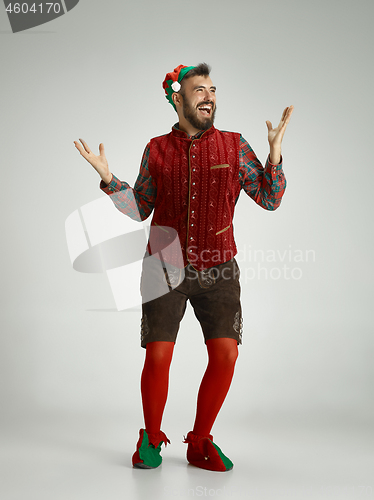 Image of friendly man dressed like a funny gnome posing on an isolated gray background