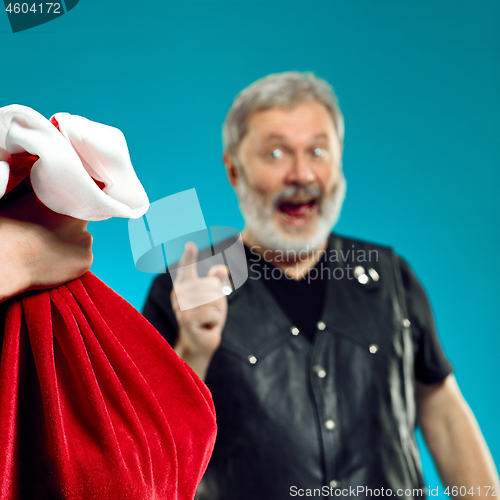 Image of An elderly man with white hair and beard and Christmas gift bag.