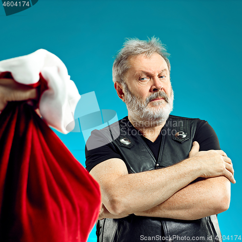 Image of An elderly man with white hair and beard and Christmas gift bag.