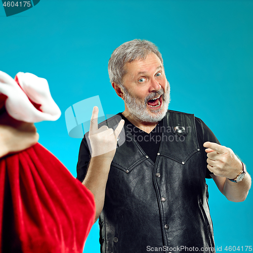 Image of An elderly man with white hair and beard and Christmas gift bag.