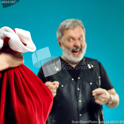 Image of An elderly man with white hair and beard and Christmas gift bag.