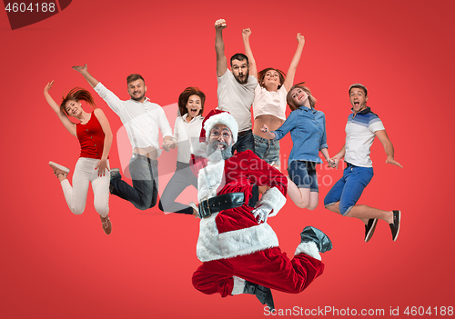 Image of Freedom in moving. young man and women jumping against red background