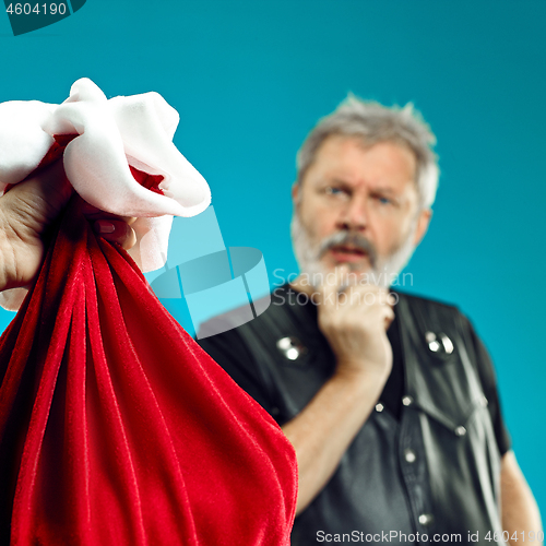 Image of An elderly man with white hair and beard and Christmas gift bag.