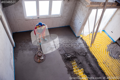 Image of worker performing and polishing sand and cement screed floor