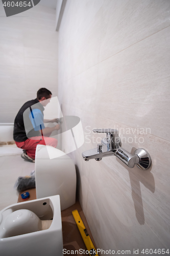 Image of professional plumber working in a bathroom