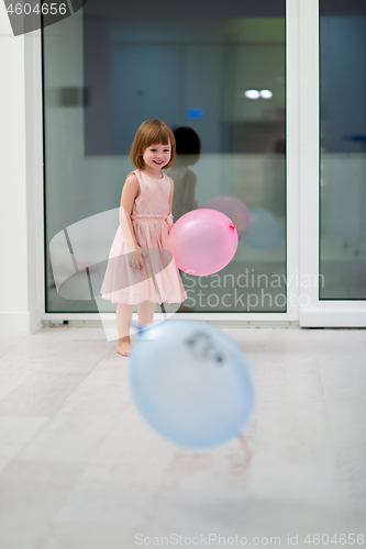 Image of cute little girl playing with balloons