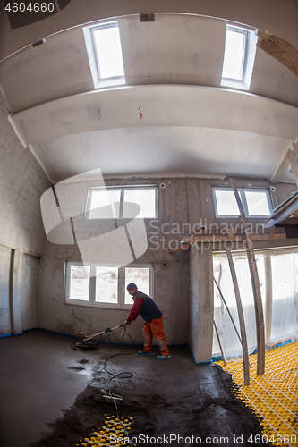 Image of worker performing and polishing sand and cement screed floor