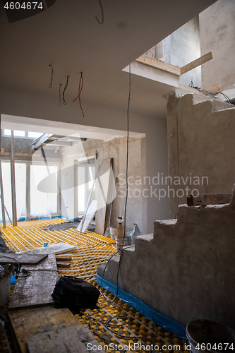 Image of yellow underfloor heating installation with white pipes