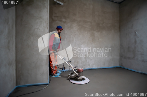 Image of worker performing and polishing sand and cement screed floor