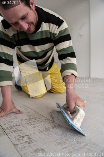 Image of Tilers filling the space between ceramic wood effect tiles