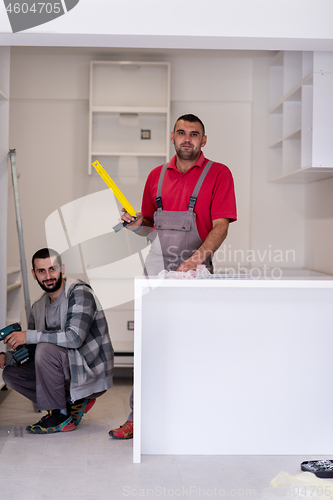 Image of young workers installing a new kitchen