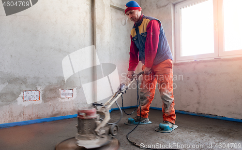 Image of worker performing and polishing sand and cement screed floor