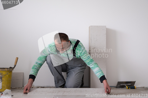 Image of worker installing the ceramic wood effect tiles on the floor