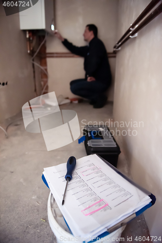 Image of engineer checking technical data of heating system