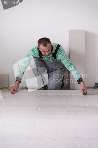 Image of worker installing the ceramic wood effect tiles on the floor