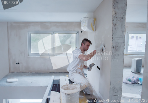 Image of construction worker plastering on gypsum walls