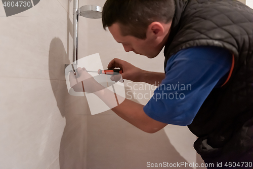 Image of professional plumber working in a bathroom