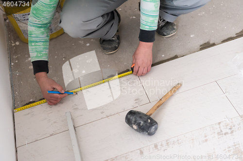 Image of worker installing the ceramic wood effect tiles on the floor