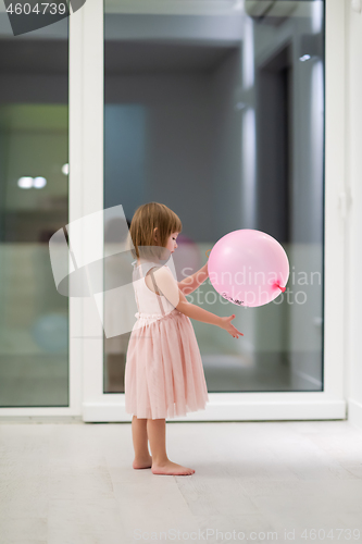 Image of cute little girl playing with balloons