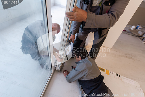 Image of carpenters installing a balcony door