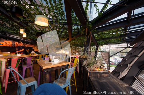 Image of blurred people in cafe decorate with hanging plant