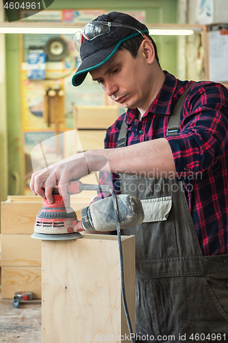 Image of Worker grinds the wood box