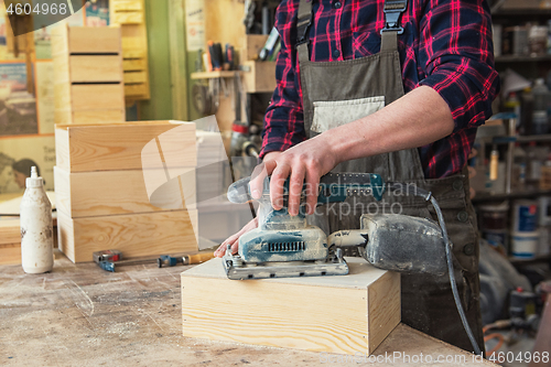 Image of Worker grinds the wood box