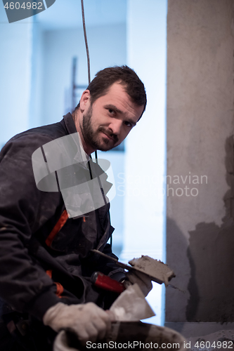 Image of Worker plastering the wall by concrete