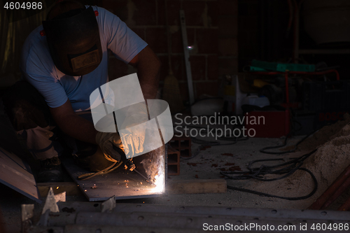 Image of welder with protective mask welding steel