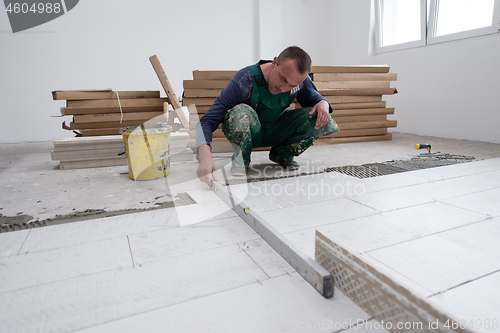 Image of worker installing the ceramic wood effect tiles on the floor