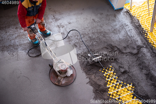 Image of worker performing and polishing sand and cement screed floor