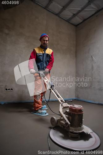 Image of worker performing and polishing sand and cement screed floor