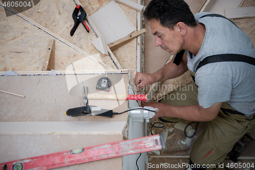 Image of carpenter installing wooden stairs