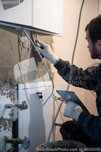 Image of Worker plastering the wall by concrete