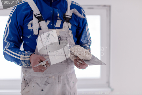 Image of construction worker plastering on gypsum walls