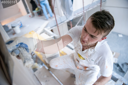 Image of construction worker plastering on gypsum walls