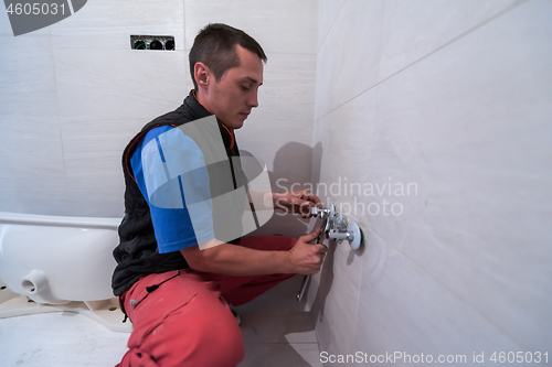 Image of professional plumber working in a bathroom