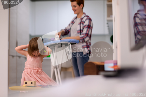 Image of mother and little daughter spending time together at home