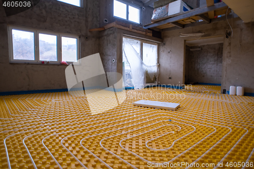 Image of yellow underfloor heating installation with white pipes