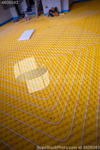 Image of yellow underfloor heating installation with white pipes