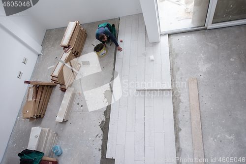 Image of worker installing the ceramic wood effect tiles on the floor