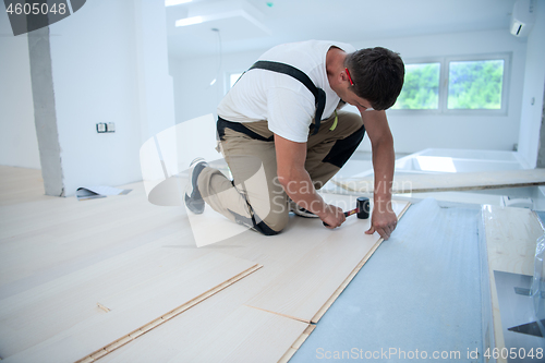 Image of Professional Worker Installing New Laminated Wooden Floor