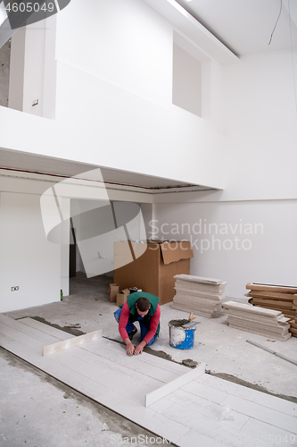 Image of worker installing the ceramic wood effect tiles on the floor