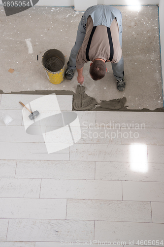 Image of worker installing the ceramic wood effect tiles on the floor